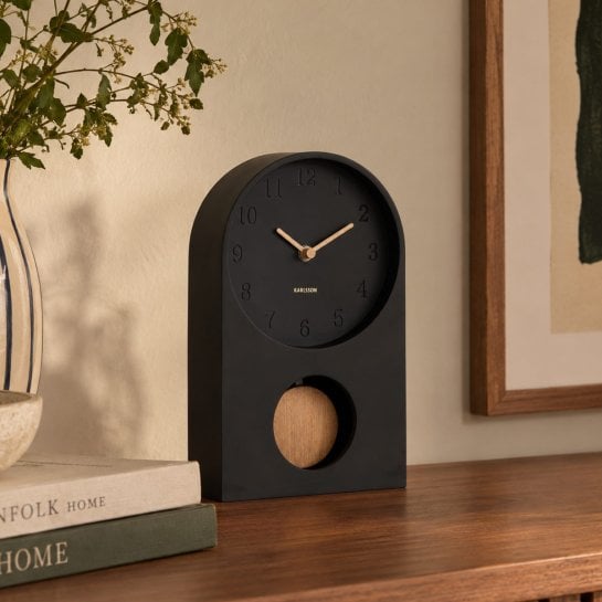 Pendule à poser au design minimaliste avec détails dorés sur les aiguilles